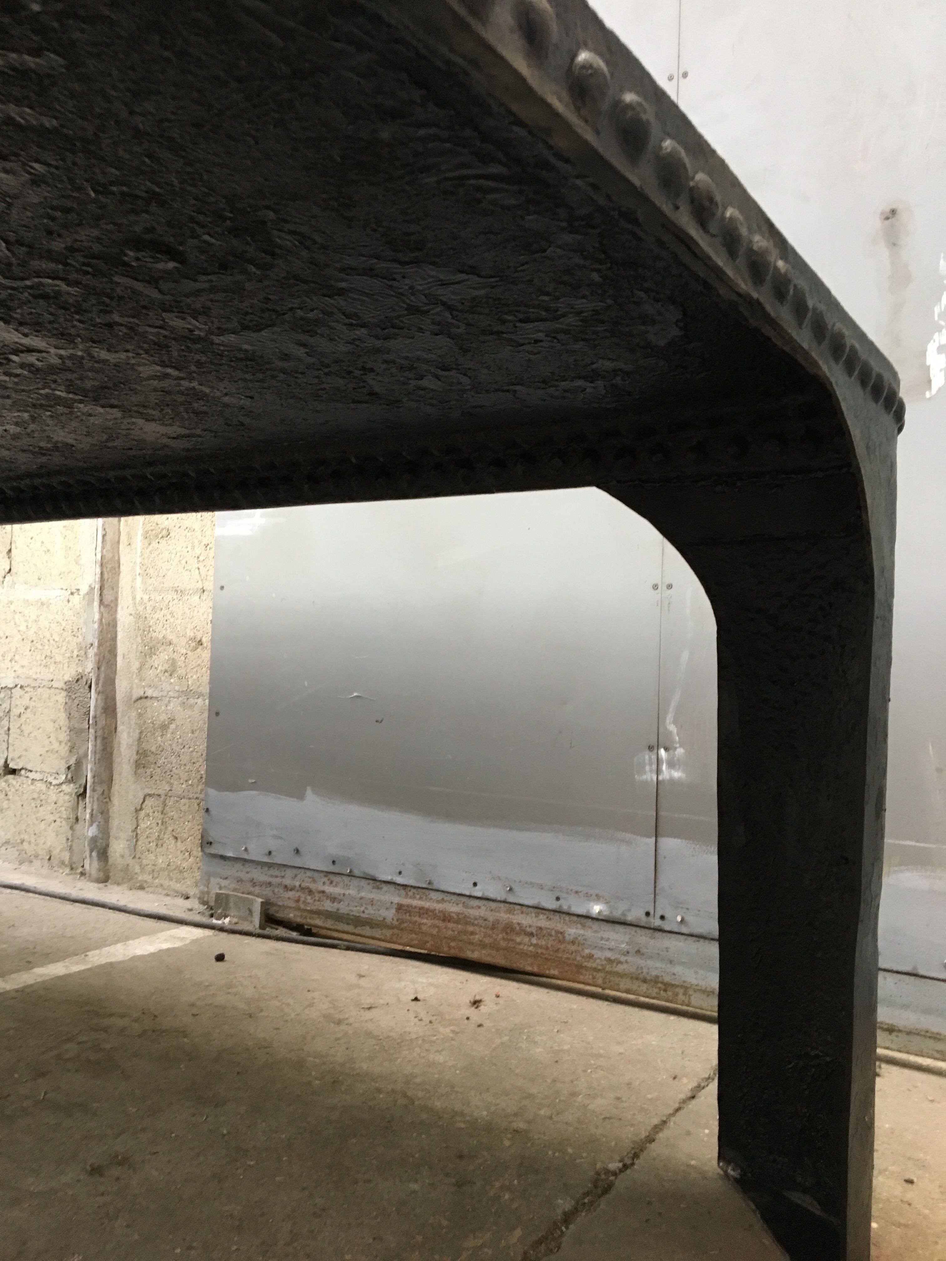 large industrial table in graphite black riveted metal