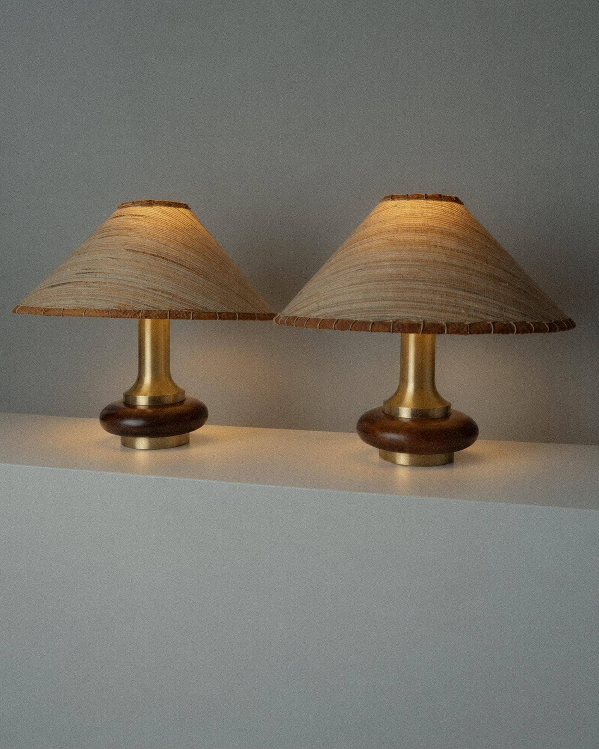 Lot of 2 vintage table lamps from the 1970s, dark wood oval bases with curved brass details, handmade natural fibre lampshades, elegant lighting.