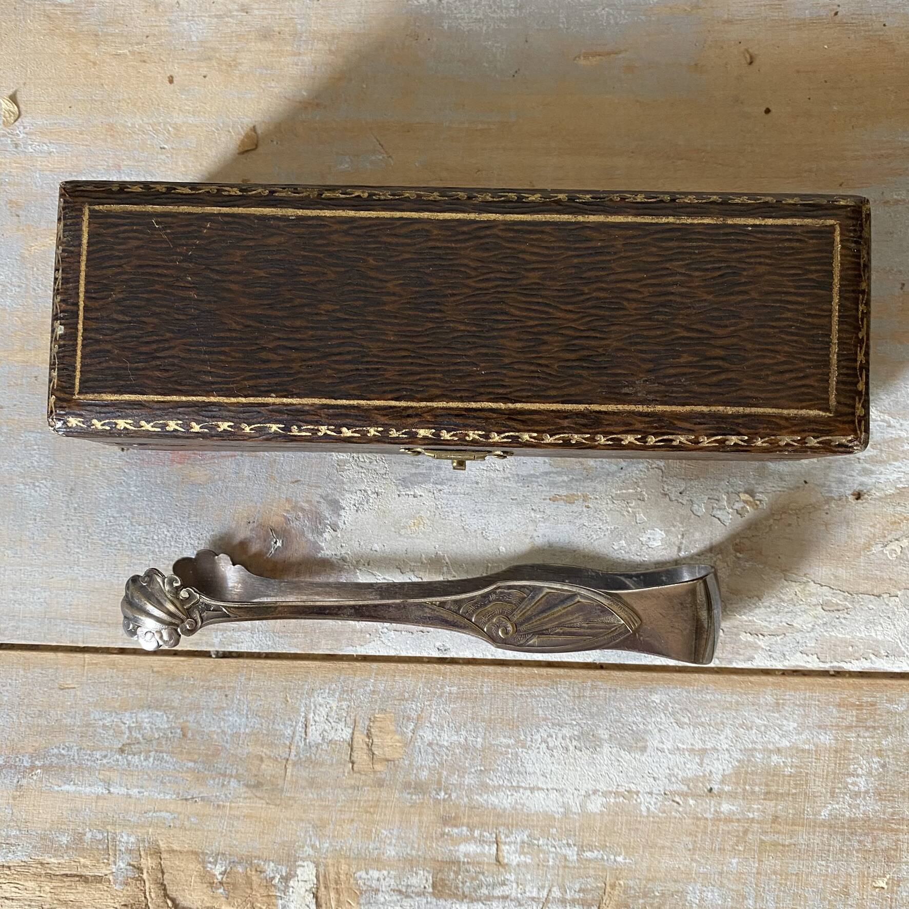 Antique sugar tongs in its case, shell decoration.
