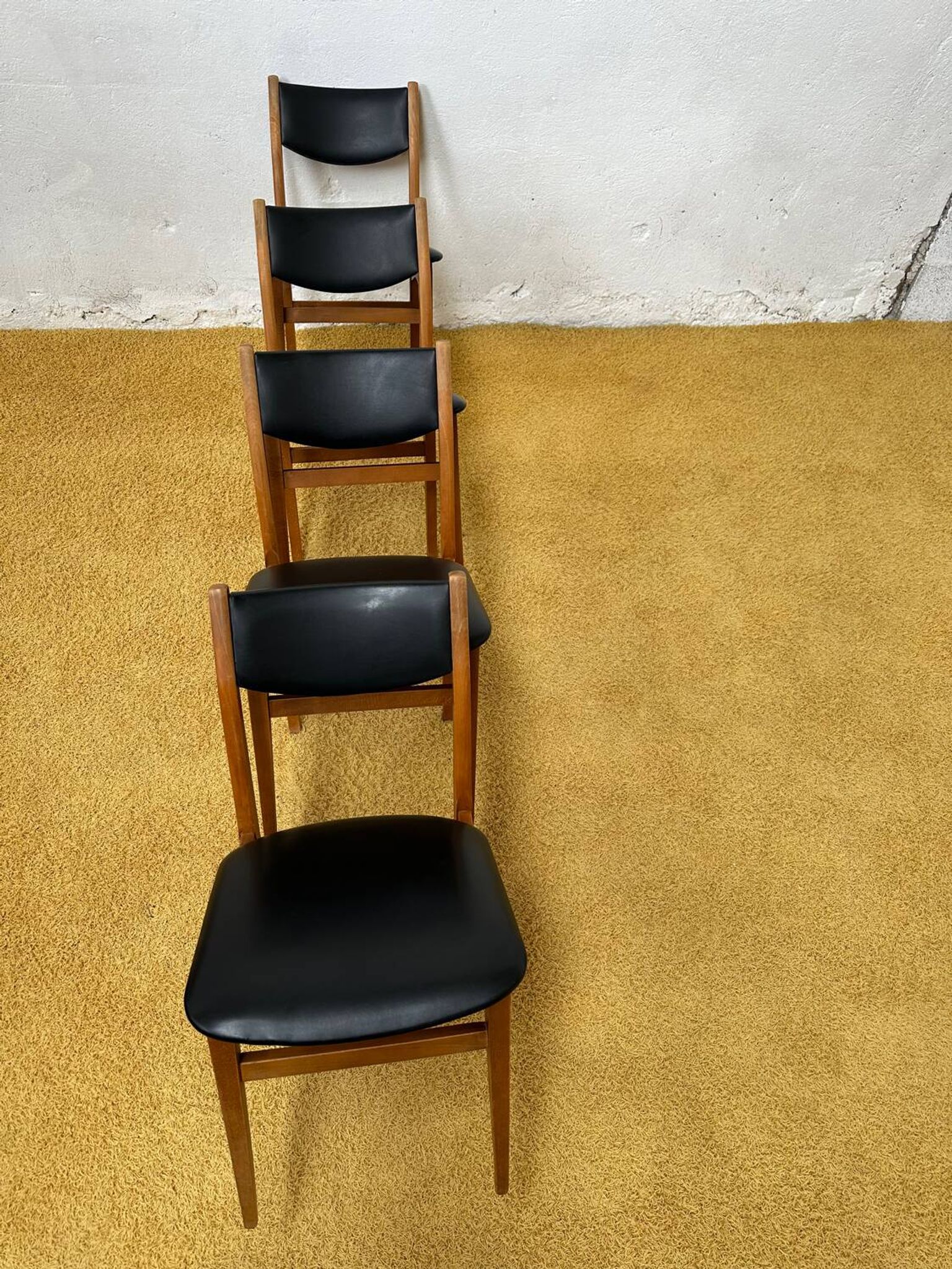 4 Scandinavian chairs in teak and black faux leather.