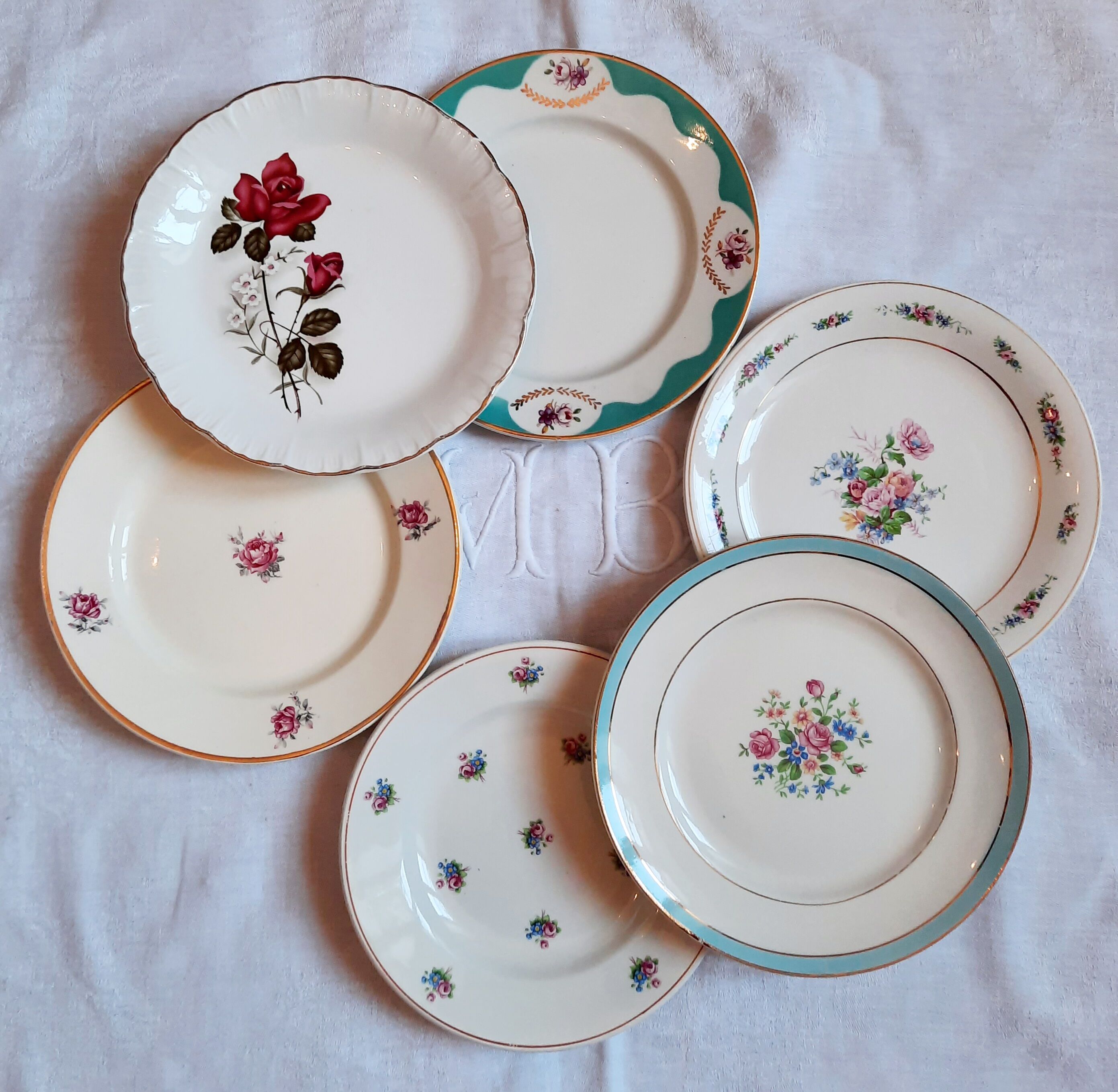 7 mismatched antique dessert plates accompanied by a pie dish