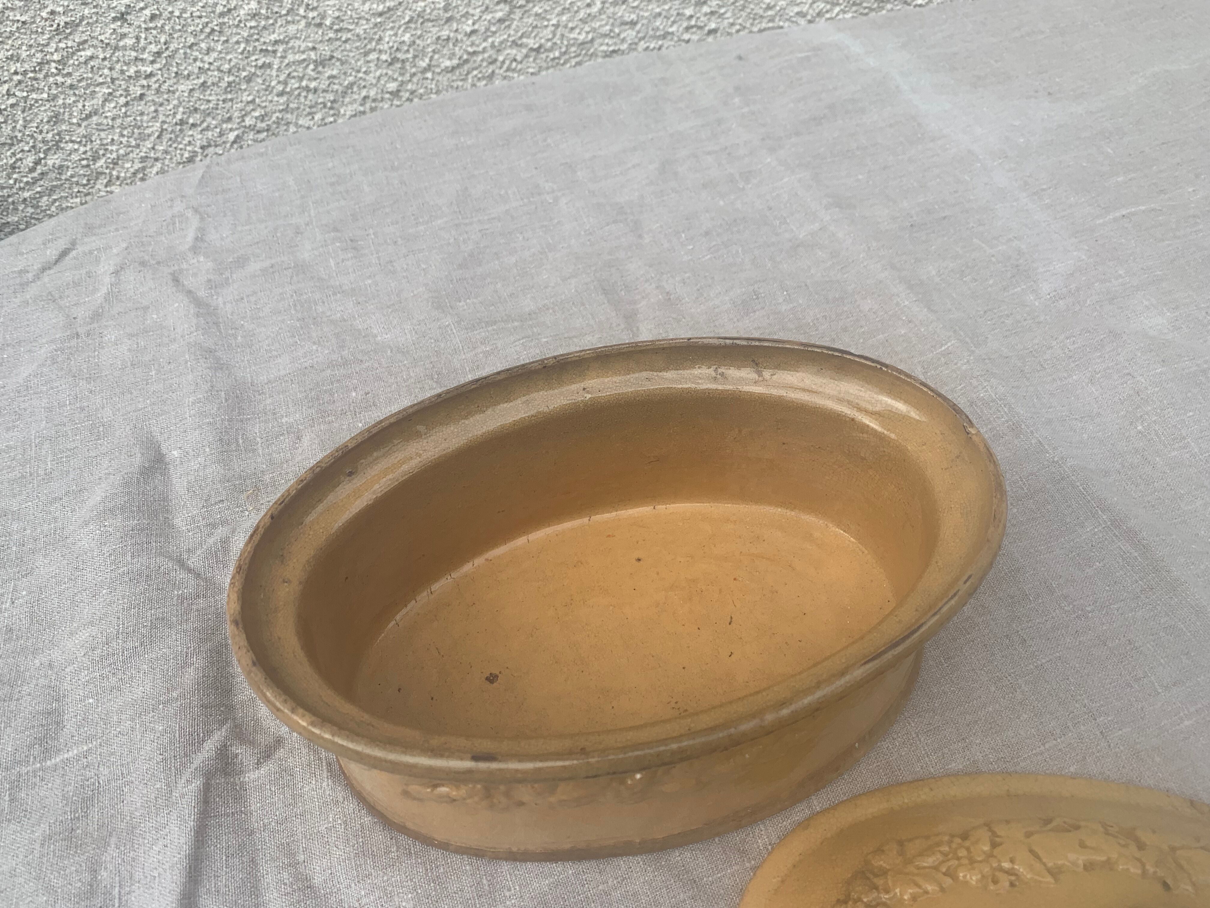 Old terrine in glazed stoneware and floral decoration mustard yellow slip