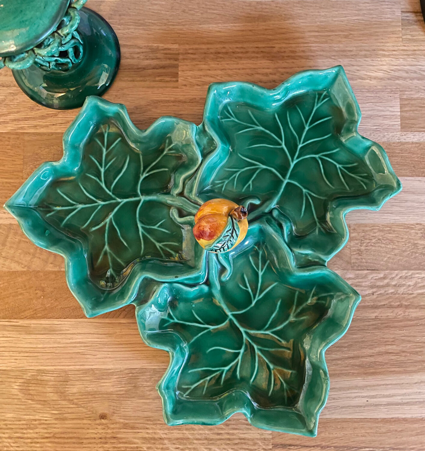 Old dish in green slip decor 3 vine leaves and an apple