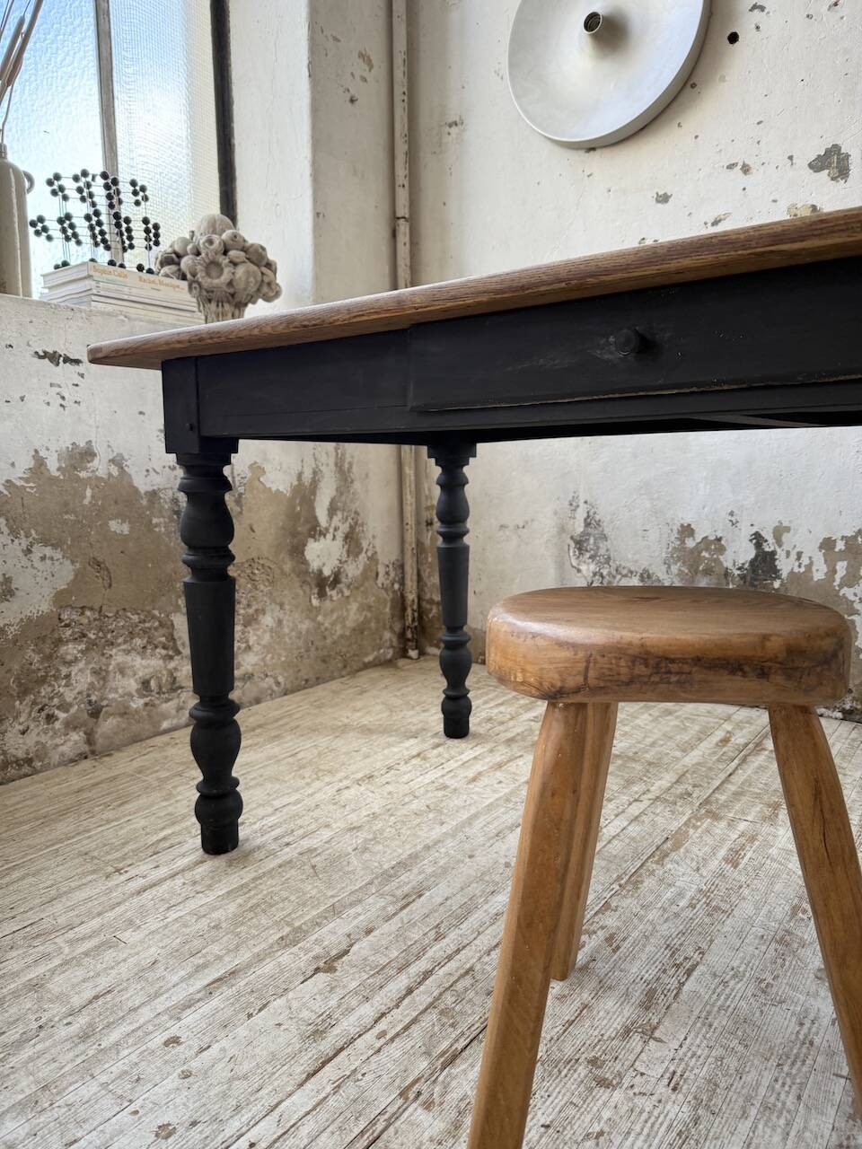 Oak farmhouse table with turned black legs.