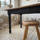 Oak farmhouse table with turned black legs.