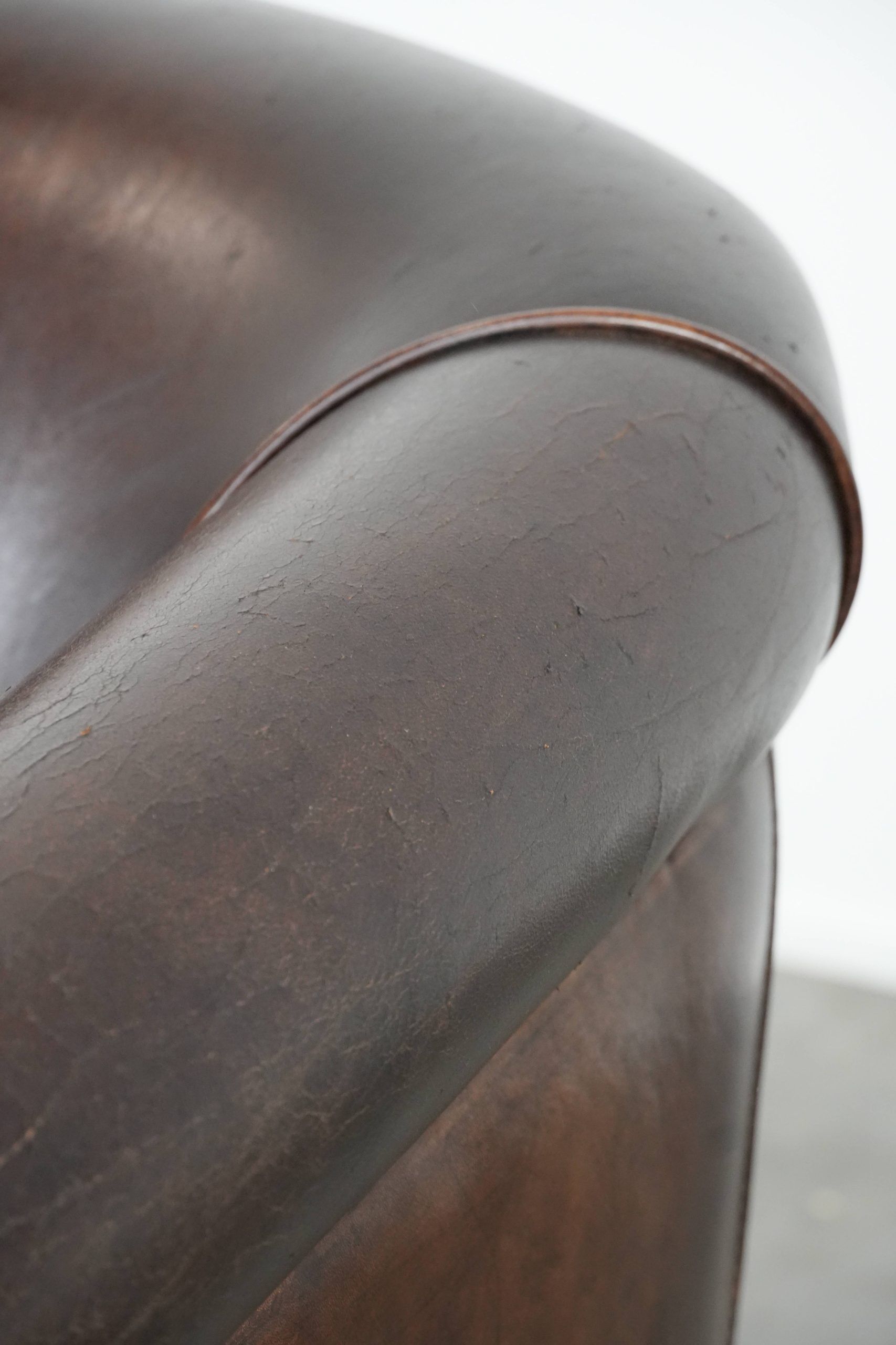 Dark brown vintage club armchair in English style made of sheepskin leather