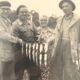Fishing trophy with radiant faces, c. 1950. Black and white photograph.