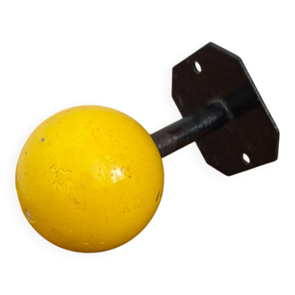 Vintage yellow wooden wall-mounted ball coat hook.