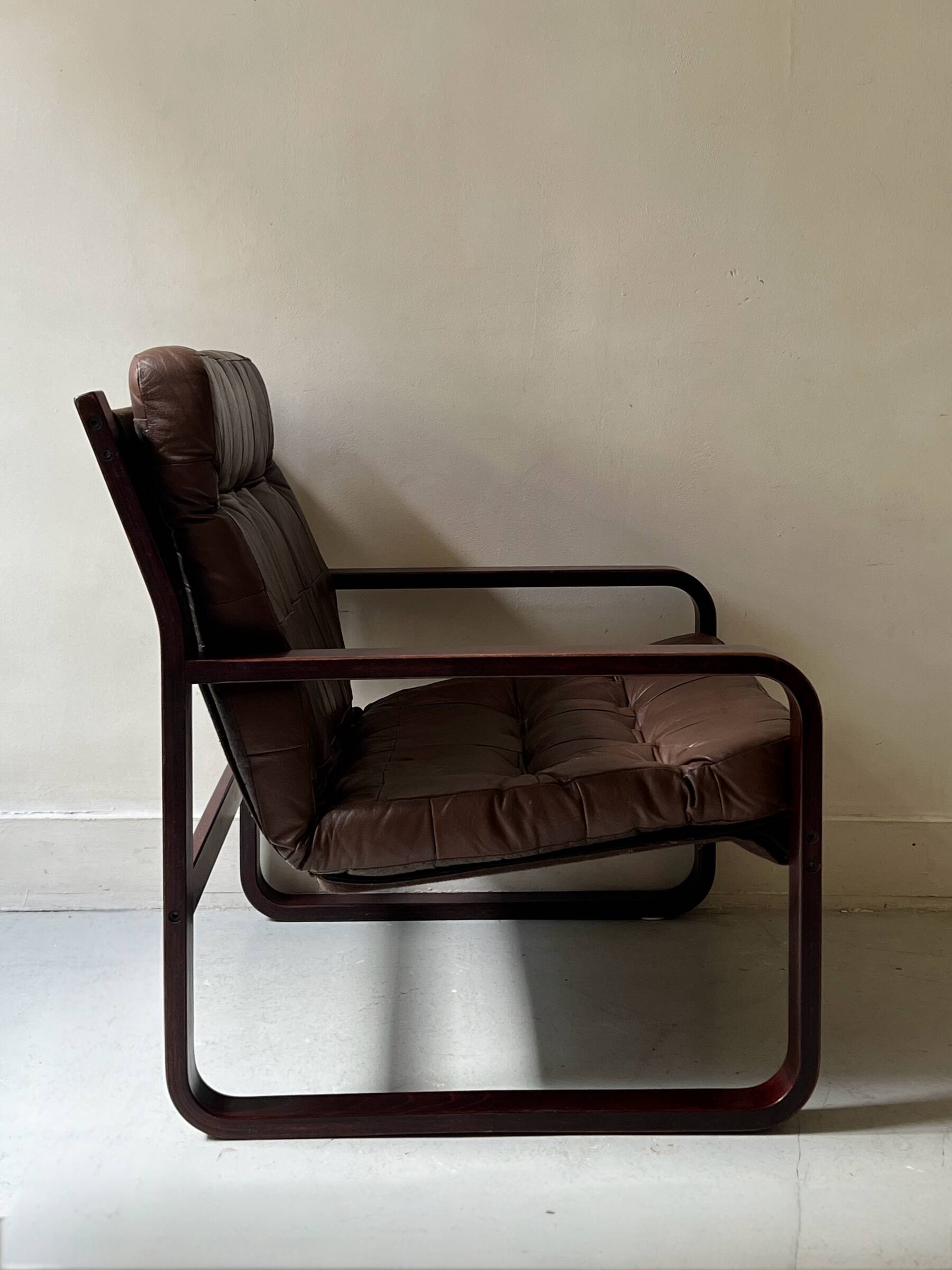Scandinavian armchair with turned wood and brown patchwork leather, 70s design.