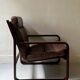 Scandinavian armchair with turned wood and brown patchwork leather, 70s design.