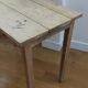 Table ancienne en bois avec inclusion de monnaies et de clés