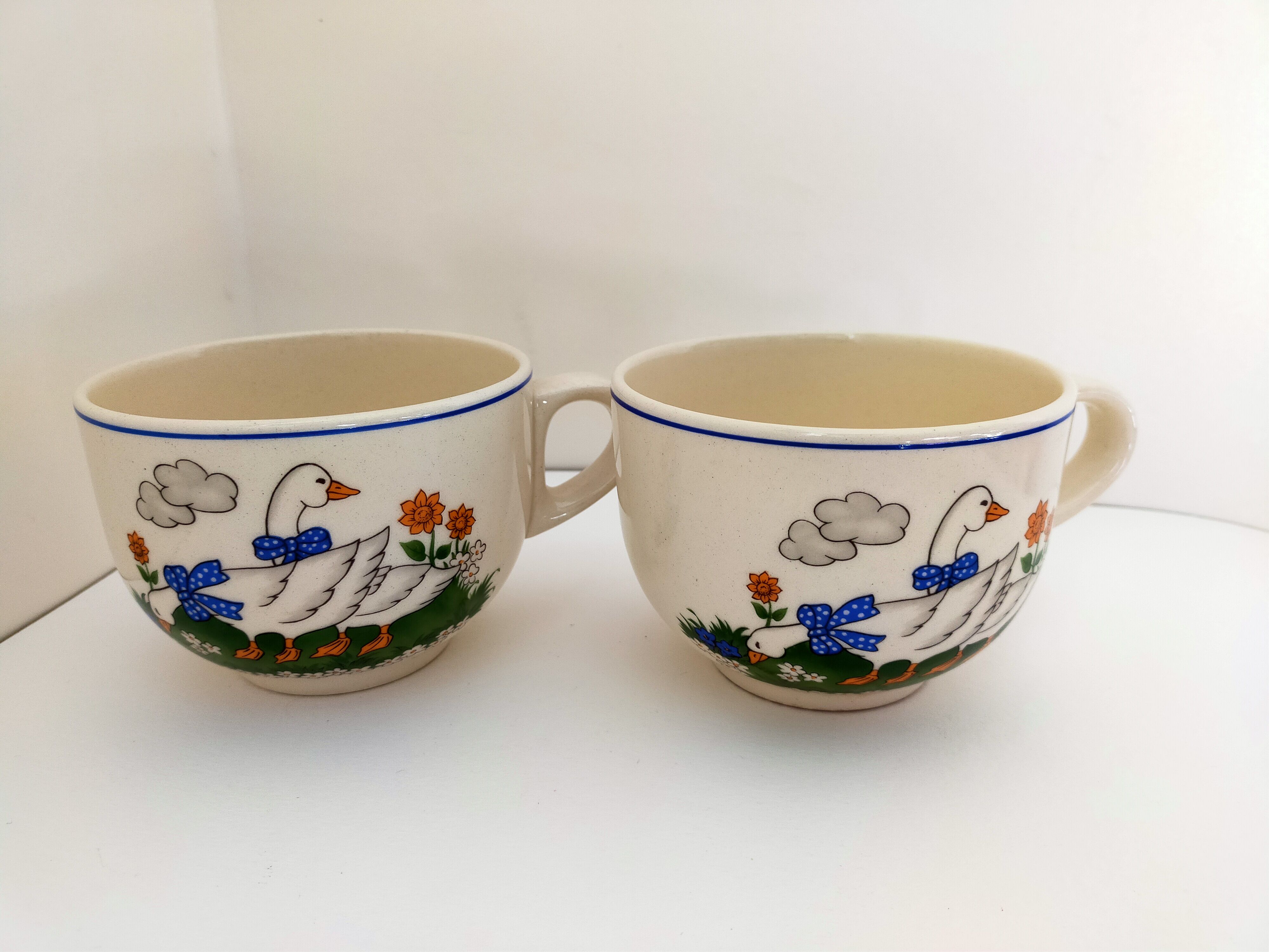 Paire de bols blancs avec anse vintage faïence art déco décor animalier:oies aux rubans bleus