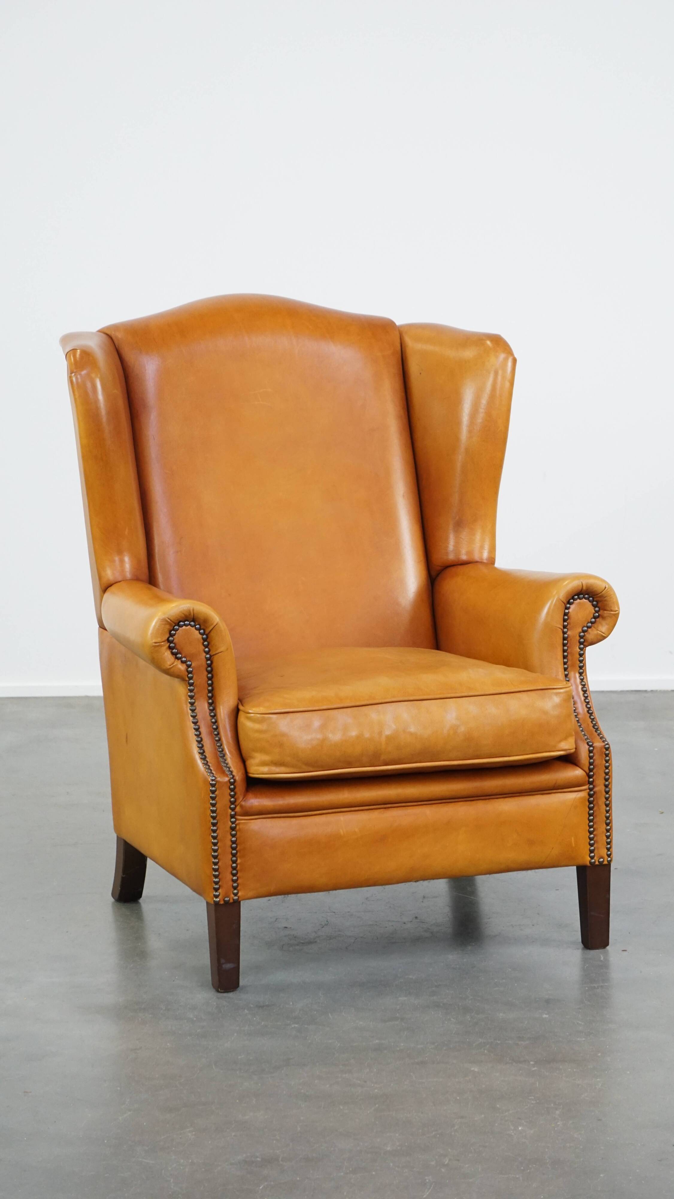 Cow leather wingback chair finished with decorative nails
