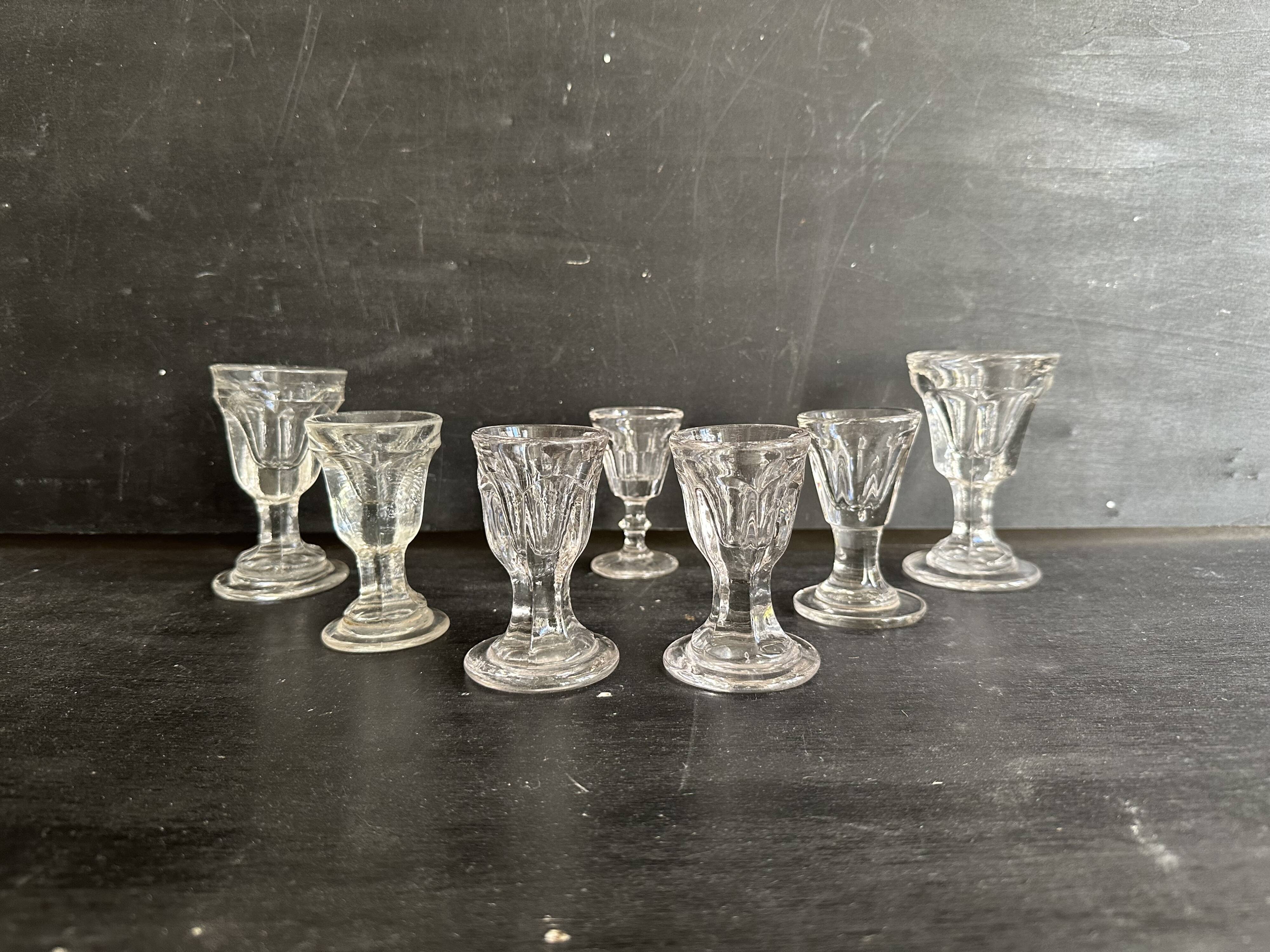 Set of antique liqueur glasses in thick glass, bistro style.