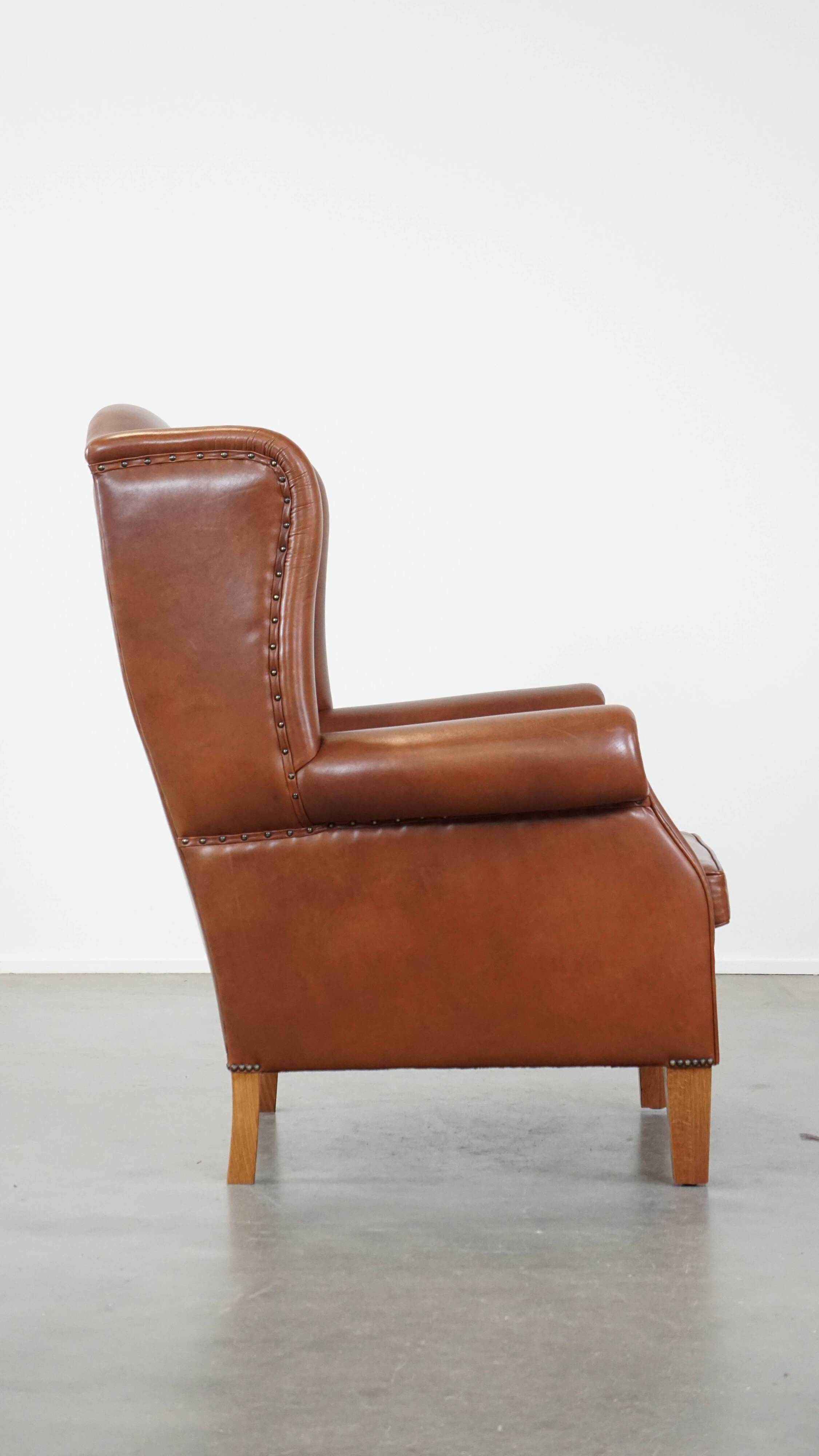 Cognac-colored leather wingback chair in English style
