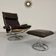 Vintage leather reclining armchair and its 1970s designer ottoman.