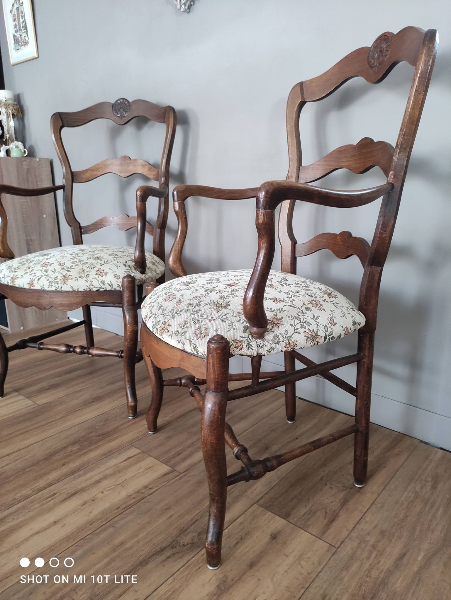 Pair of Provençal armchairs in brown wood and floral fabric.