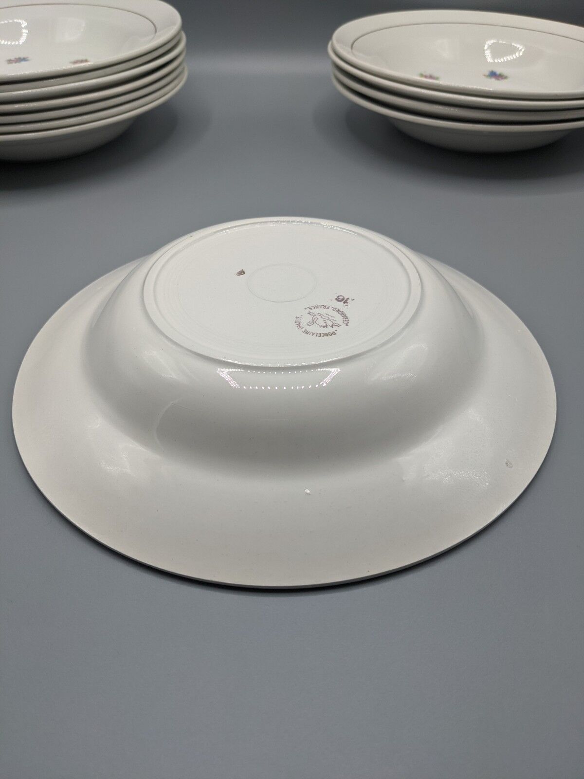 12 hollow porcelain plates, floral decoration and golden ledé - ∅: 23cm