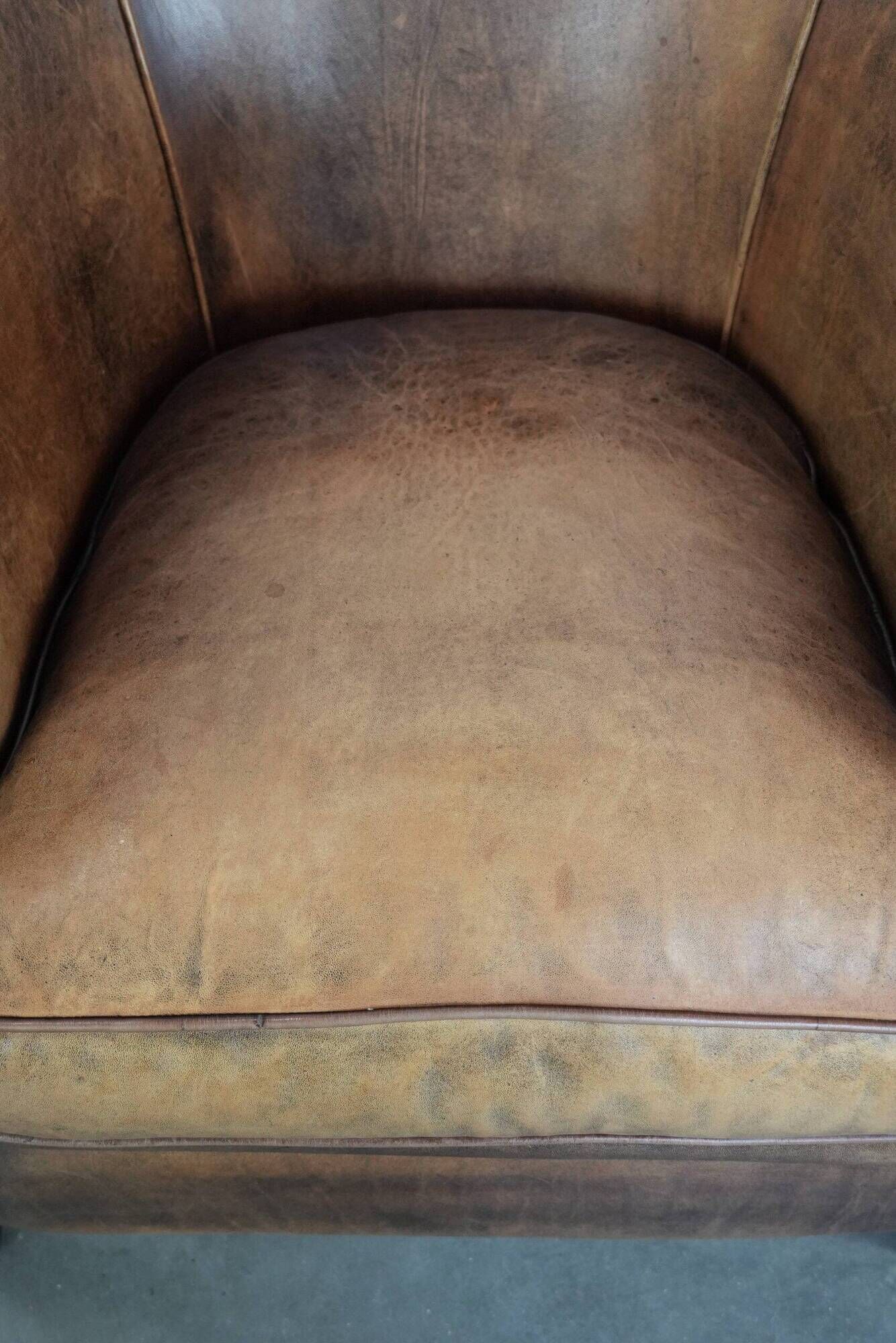 Club chair made of sheepskin leather finished with decorative nails