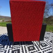 Pair of vintage armchairs in black faux leather and red fabric.