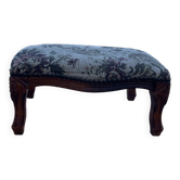 Antique wooden footstool with hand-carved details and floral upholstery –