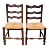 2 solid wood chairs with carved rush seats