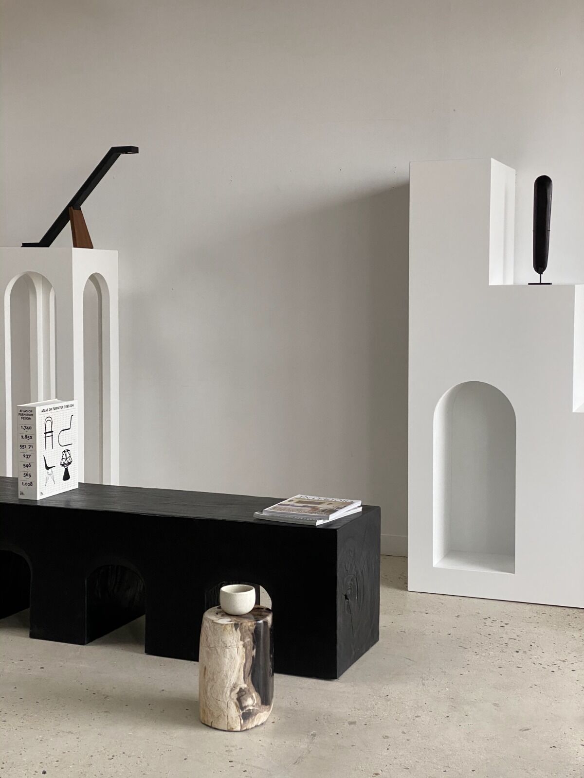 Black solid monoxyl wood bench carved into 3 arches