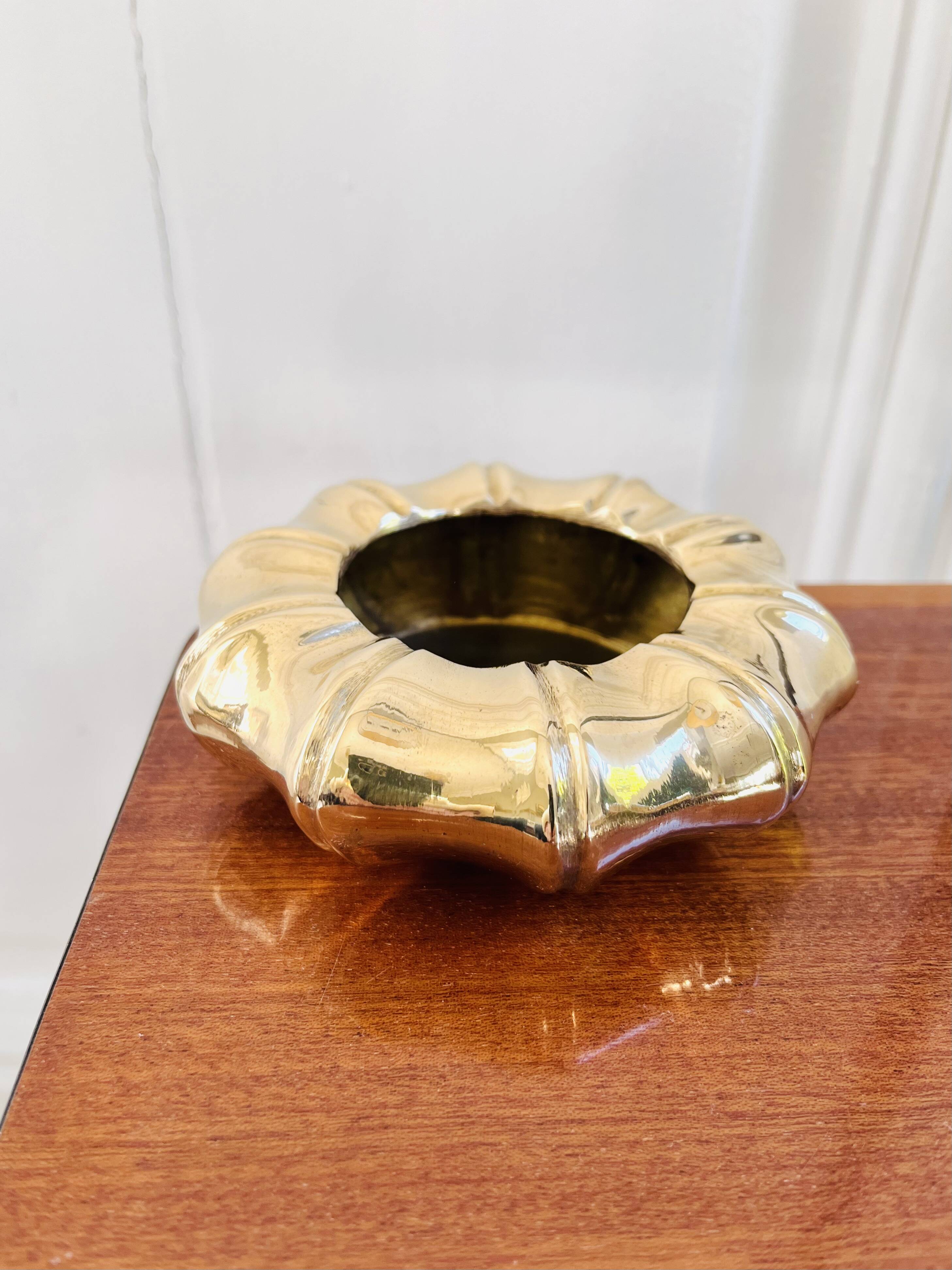 Golden brass ashtray with bamboo decoration.