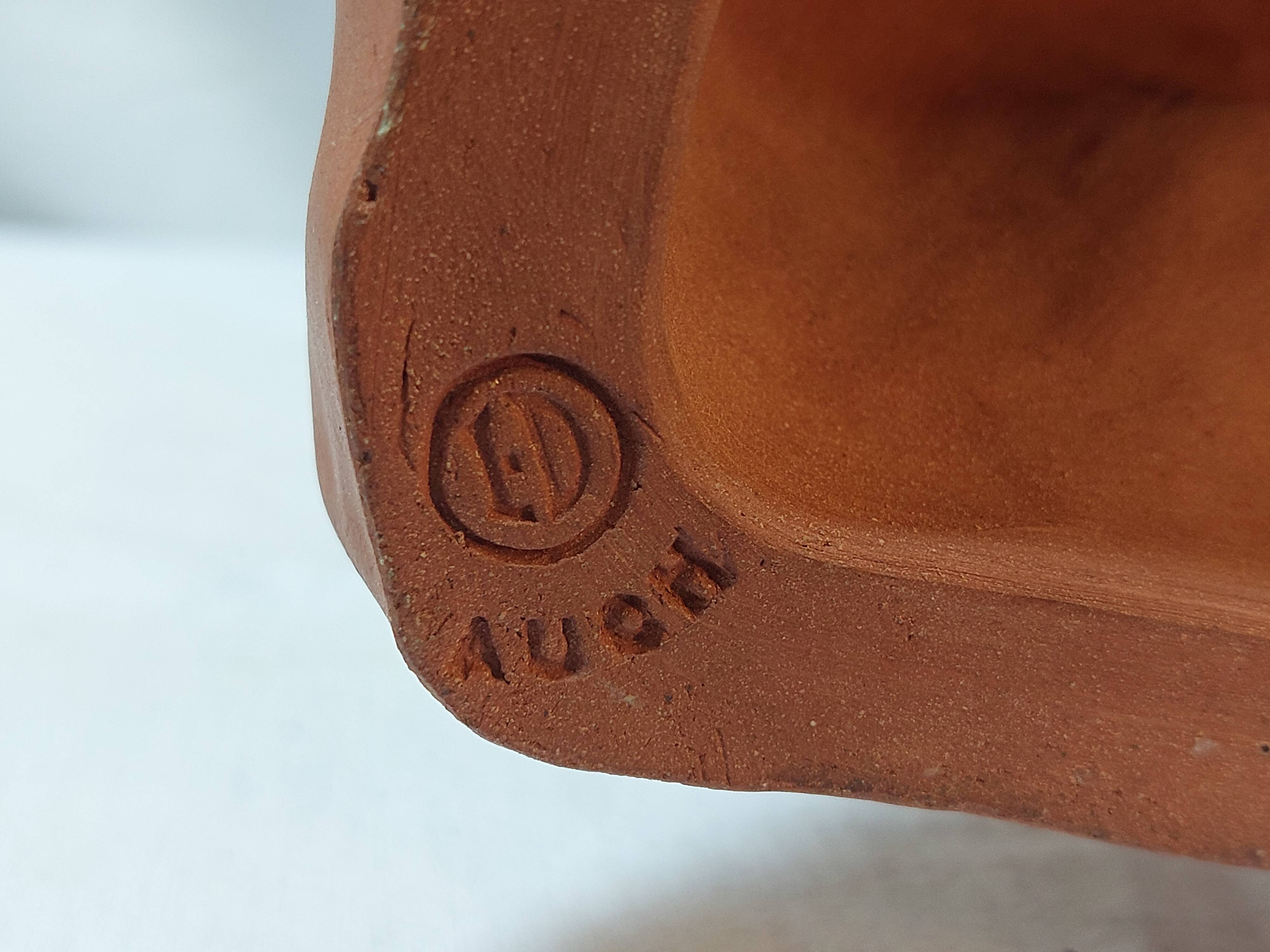 Terracotta bust of a smiling little boy.