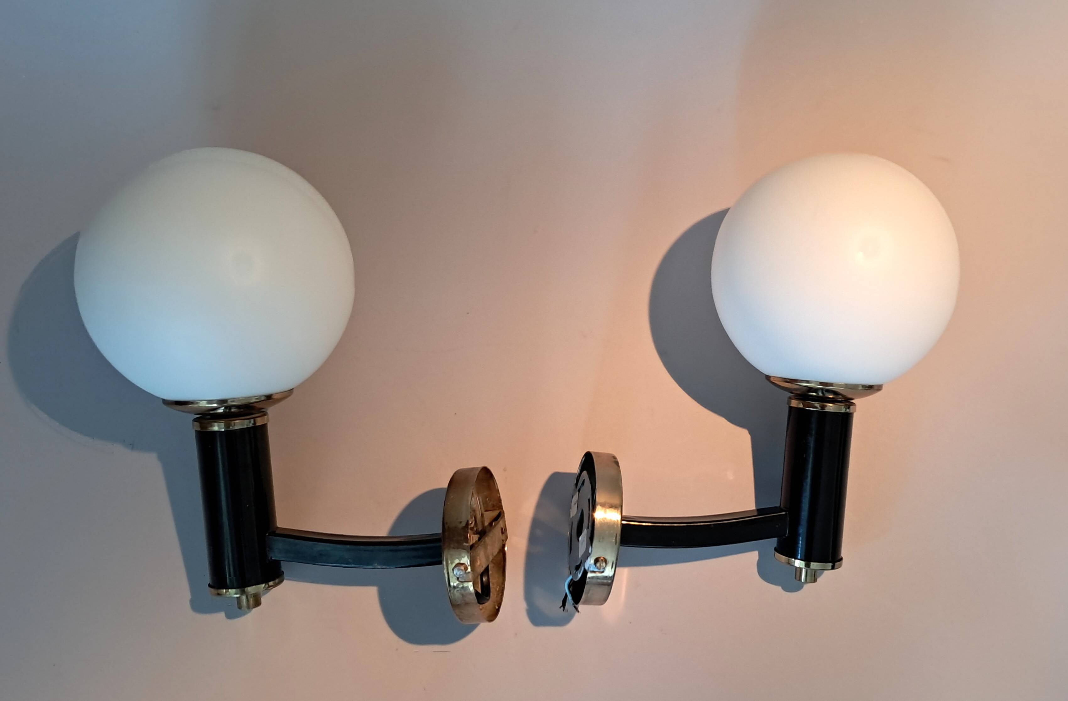 Pair of wall lights in gilded and black lacquered brass, Italy 1970/1980.