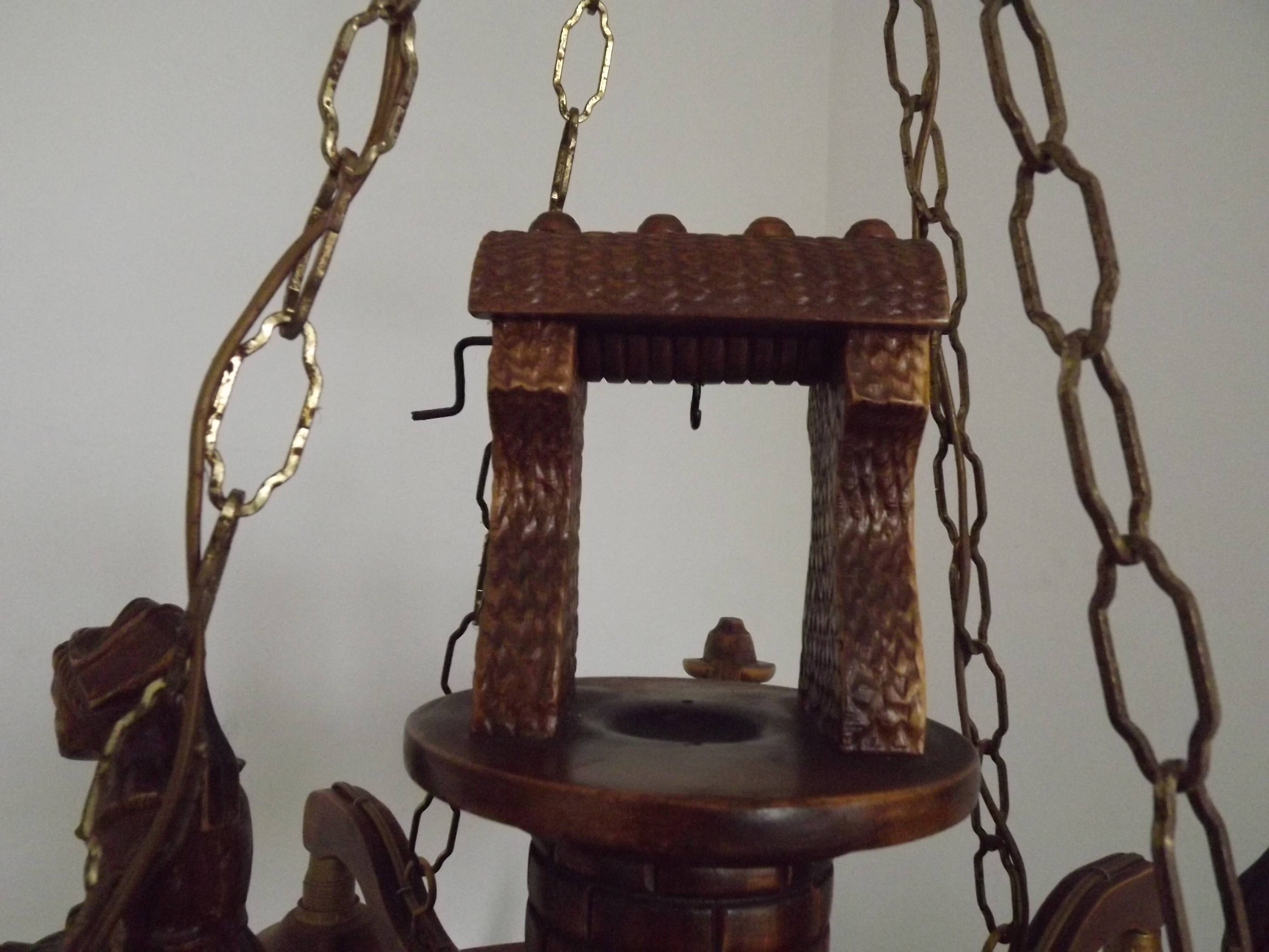 French vintage Breton chandelier with hand-carved figures, well, and lantern lights.