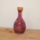 Vintage pink pressed glass carafe – retro decorative bottle with wooden stopper.