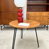 Round side table with black lacquered metal hairpin legs.