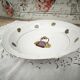 Shallow round plate in Limoges porcelain with a hydrangea basket design.