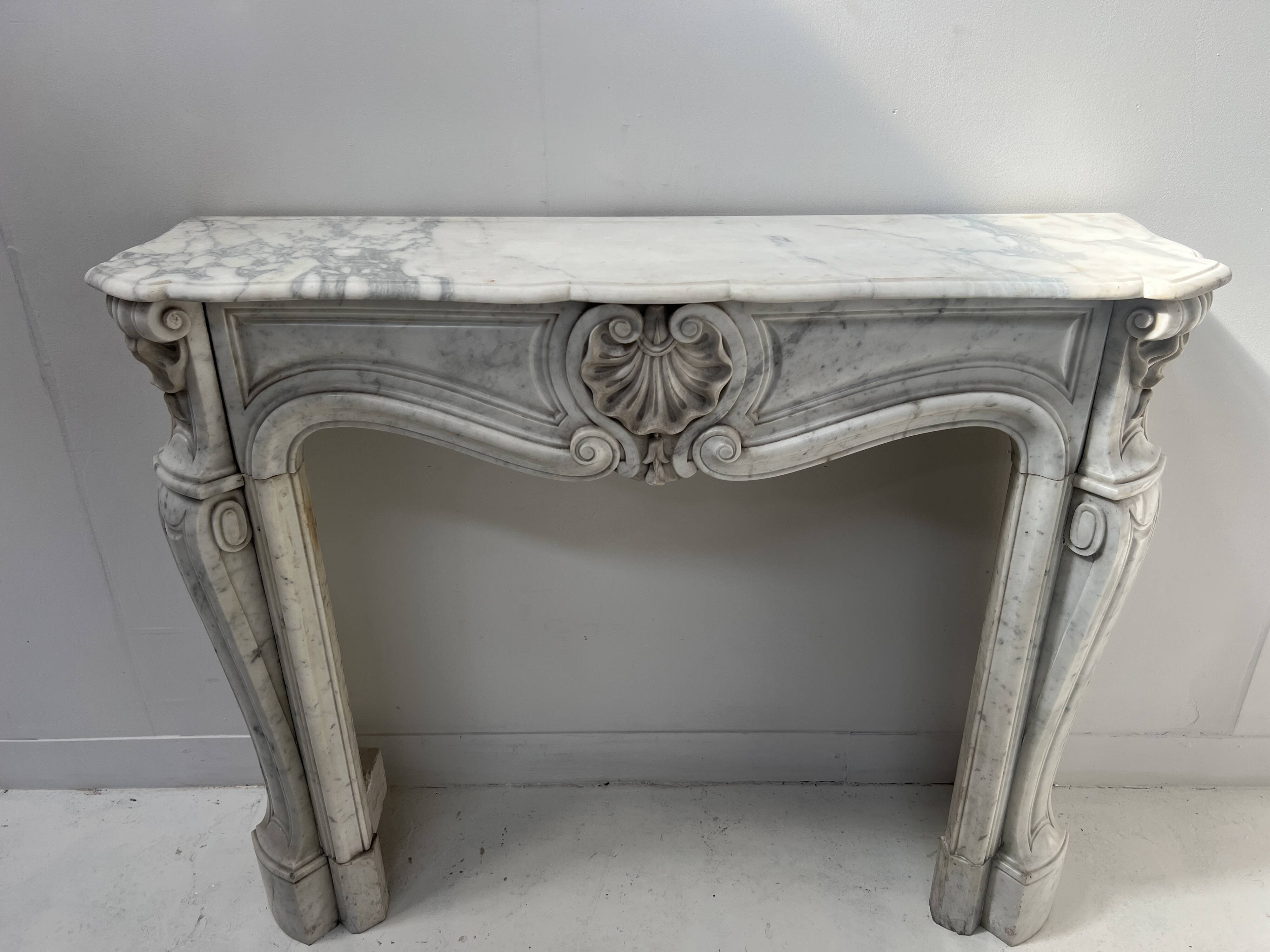 Louis XV style fireplace in veined white Carrara marble, 19th century.