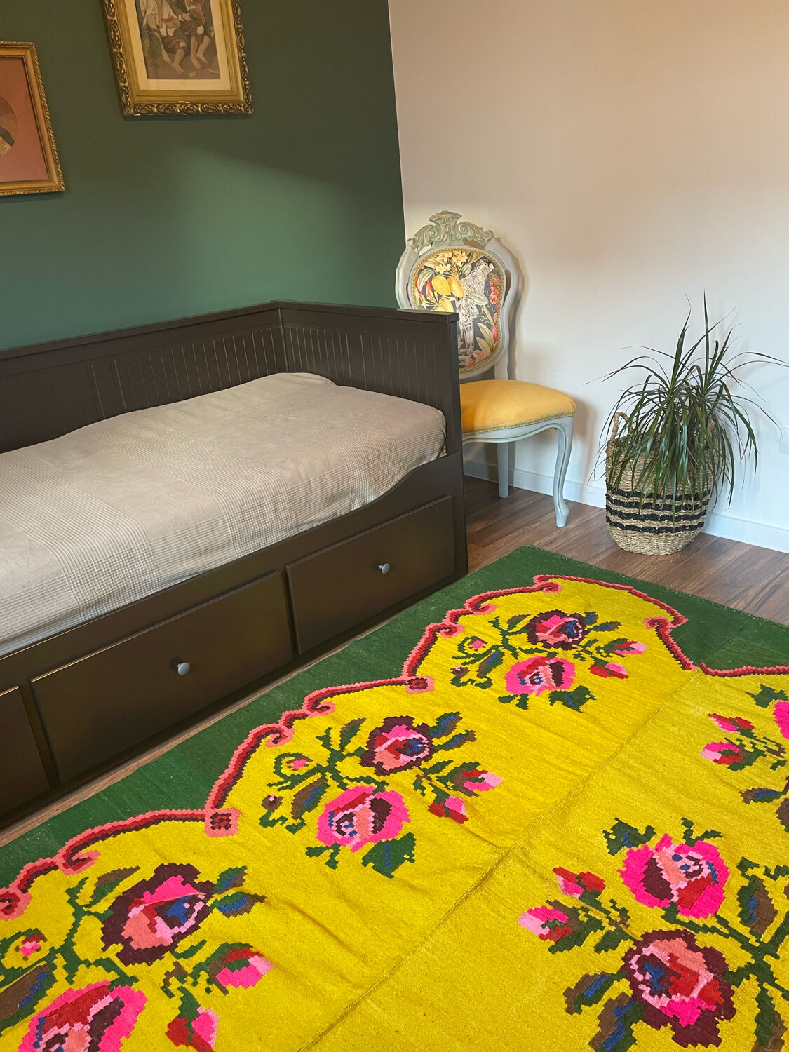 Vintage wool rug with pink flowers on green and yellow background made by hand in Transylvania