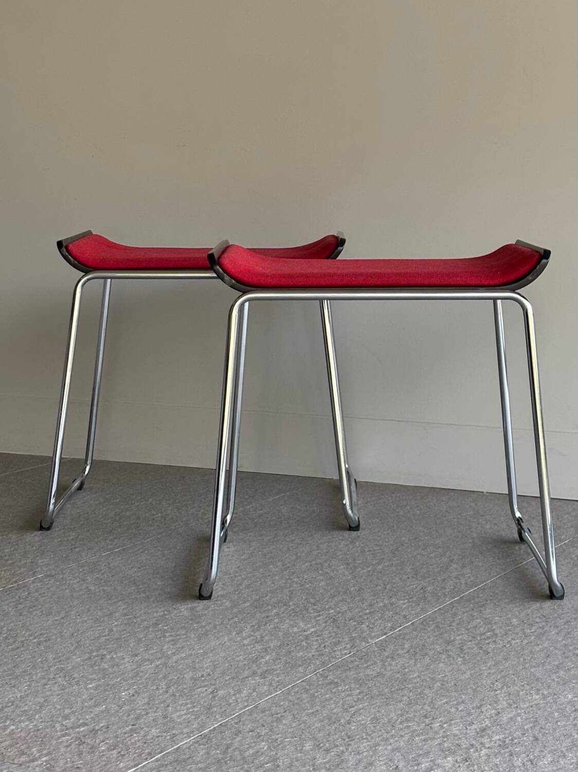 Pair of minimalist stools in red fabric with chrome legs