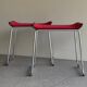 Pair of minimalist stools in red fabric with chrome legs