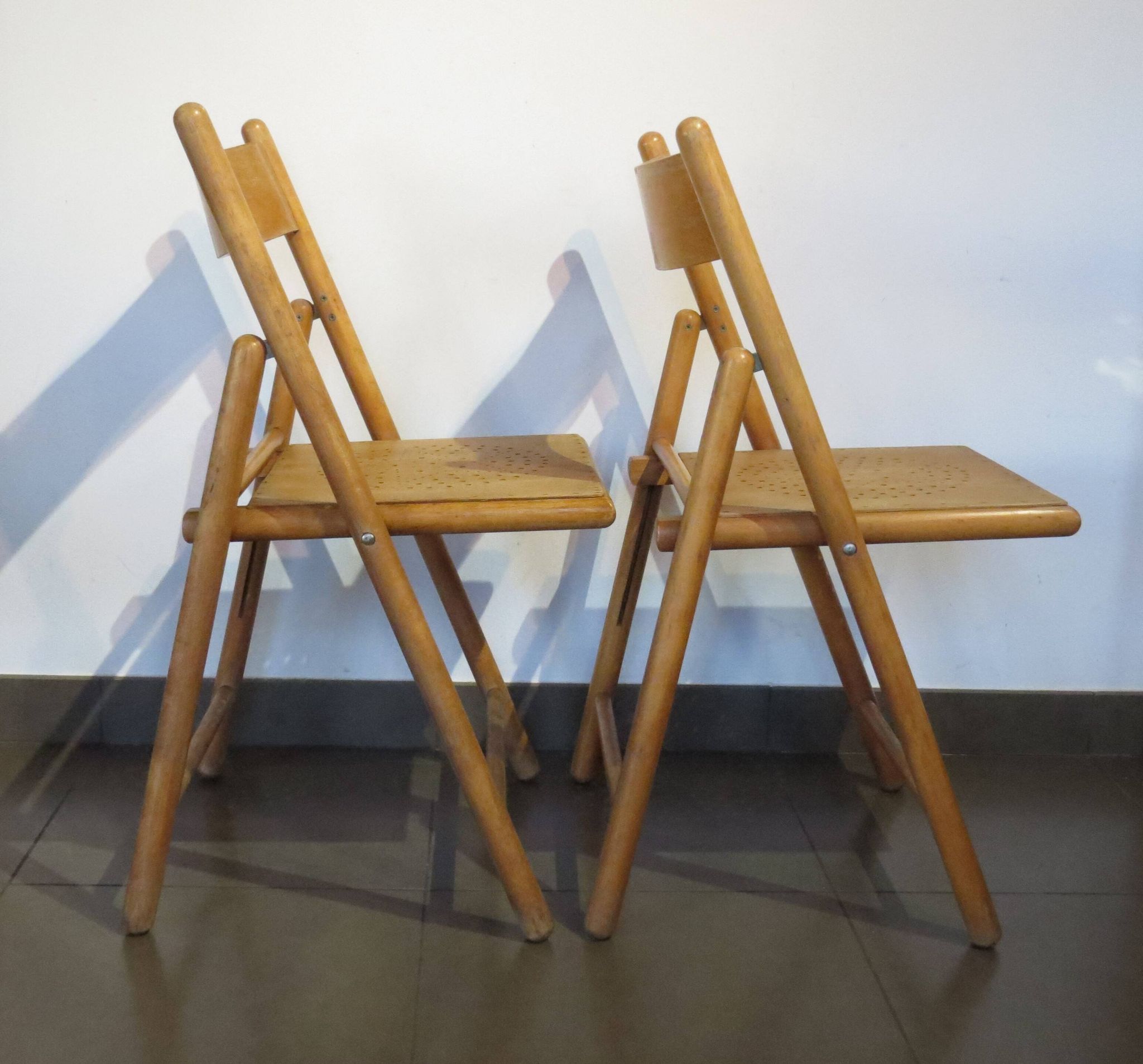Pair of vintage wooden folding chairs with star pattern on seat