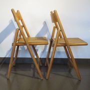 Pair of vintage wooden folding chairs with star pattern on seat