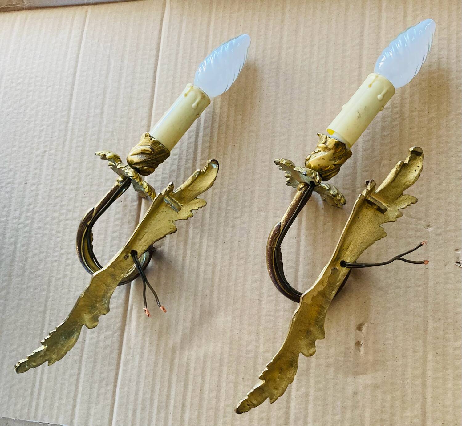 Bronze wall lights in the Louis XV style with curved branches and leaf decorations.