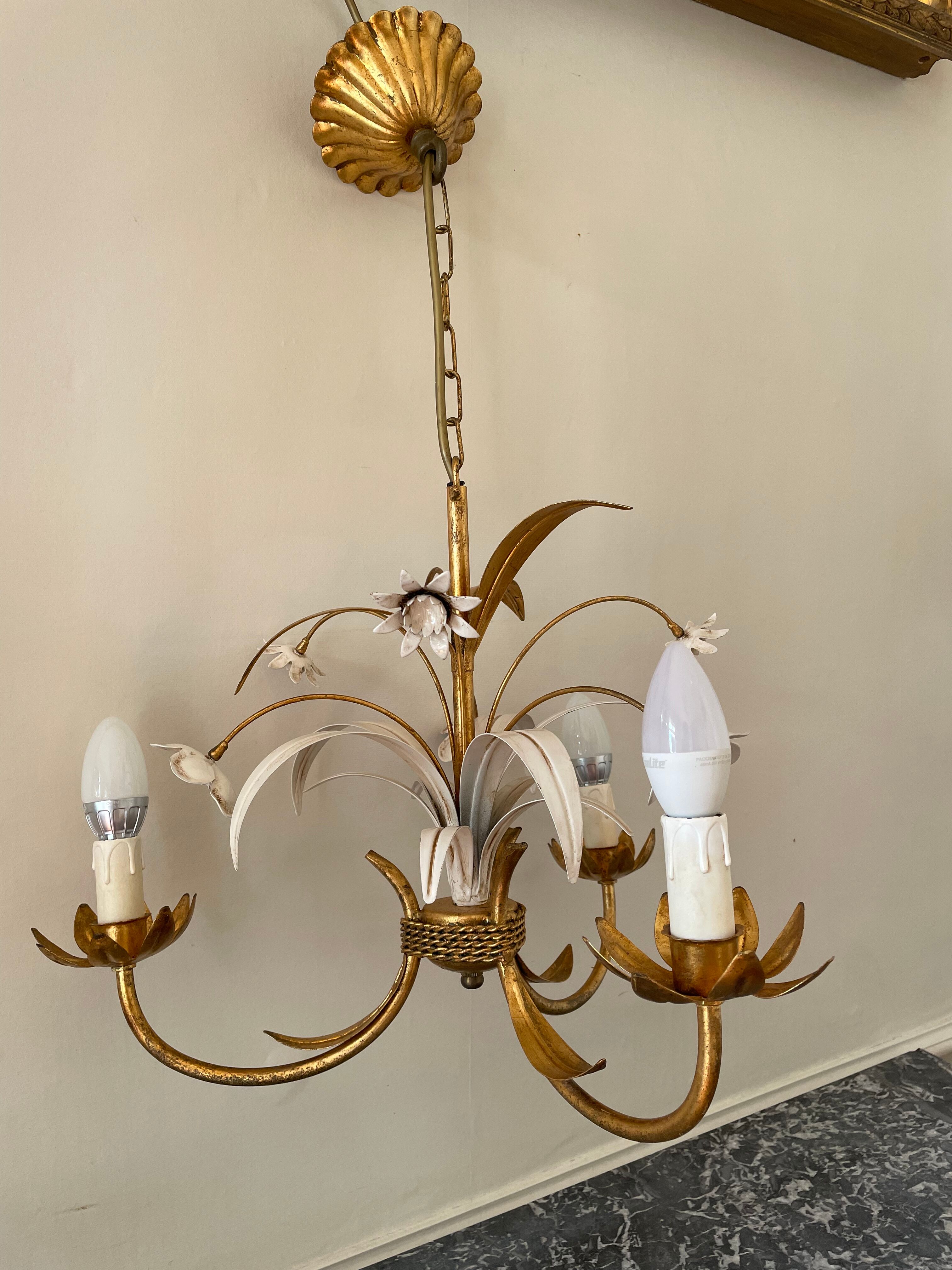 Golden metal chandelier decorated with flowers