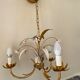 Golden metal chandelier decorated with flowers
