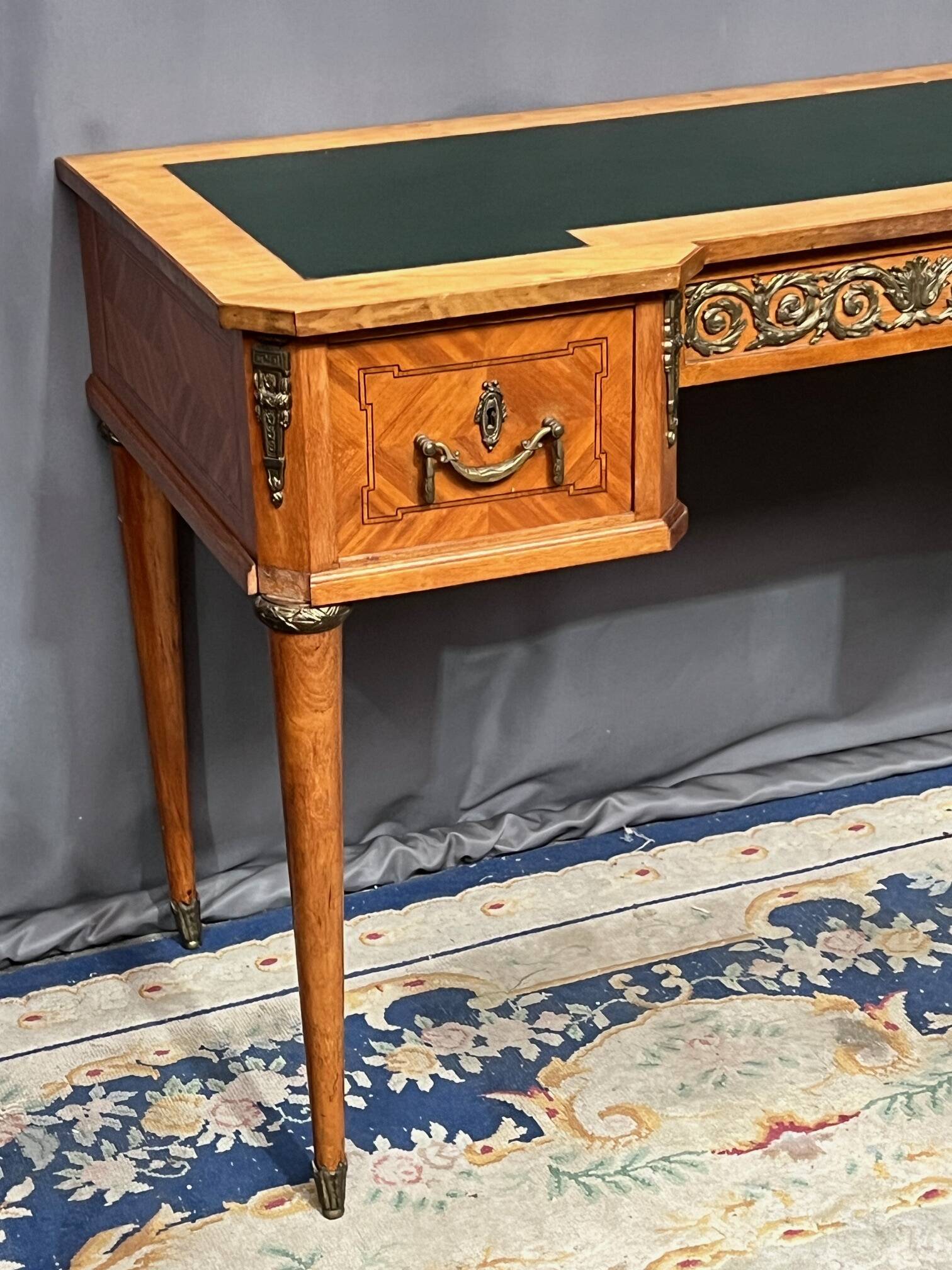 Louis XVI style marquetry desk. The top is decorated with green leather.
