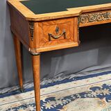 Louis XVI style marquetry desk. The top is decorated with green leather.