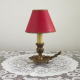Vintage French bronze Wee Willie Winkie style lamp with red card shade.