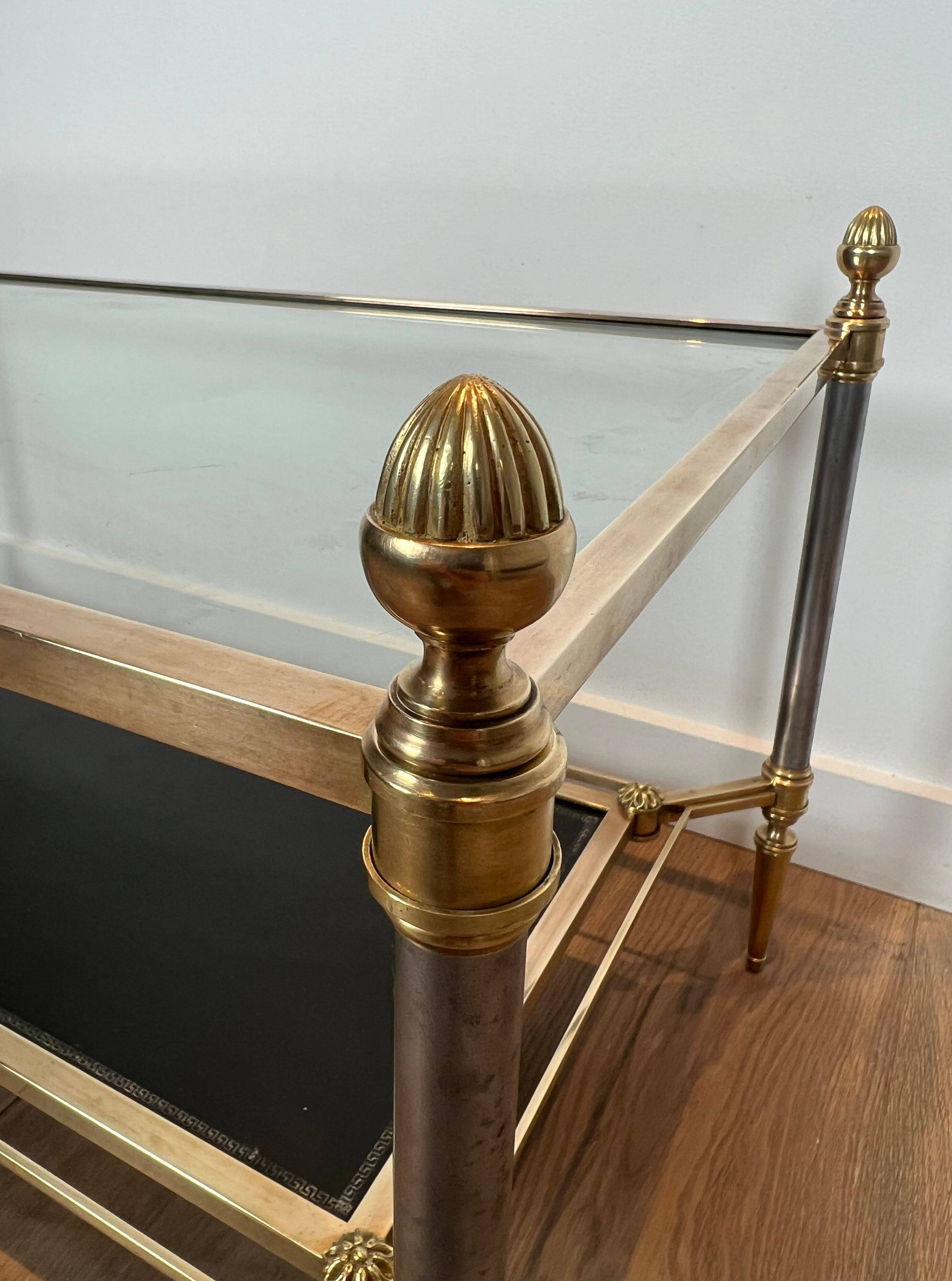 Brass coffee table with a black leather top and golden edges from Maison Jansen.