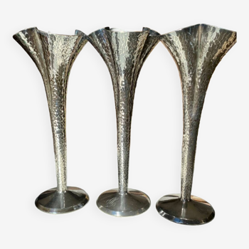 Triptych of hammered silver metal vases