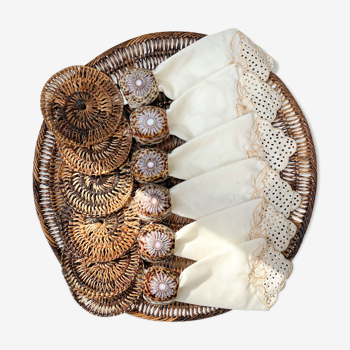 Rattan table set, under glass, embroidered napkins and cauris shell napkin round