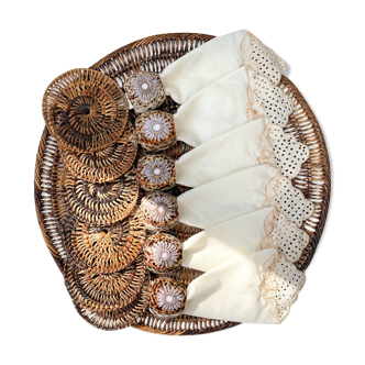 Rattan table set, under glass, embroidered napkins and cauris shell napkin round